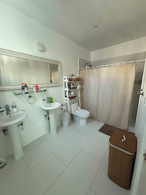 Ein Badezimmer mit Waschbecken, Toilette und Duschvorhang.