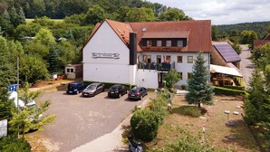 A building with a sloped roof, a sign reading 'La Maison de la Nature,' and a parking area with several cars. - Room 'Zimmer 23' with Shared Terrace, Shared Garden and Wi-Fi (Markt Erlbach)