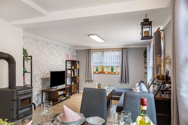 Un salon avec une cheminée, un téléviseur, un canapé et une table à manger.
