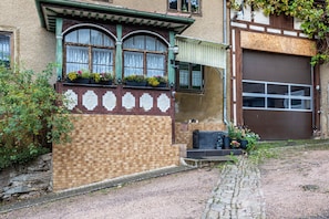 Un bâtiment avec une façade en briques, une porte de garage et une fenêtre agrémentée de jardinières.