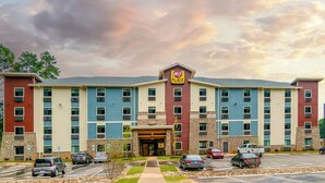 A multi-story hotel with a 'My Place' sign, featuring a central entrance, parking lot, and a mix of brick and siding exteriors. - Cozy 2 queen hotel in delightful Huntersville up to 4 people (Huntersville)