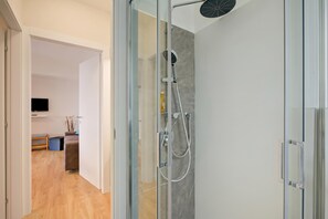 Ein modernes Badezimmer mit Duschkabine aus Glas sowie einer Handbrause.