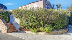 A building with a stone staircase leading to a door, surrounded by lush greenery and a clear blue sky. - Studio Pinet - Near St Tropez - Pool, Ramatuelle, France (Ramatuelle)