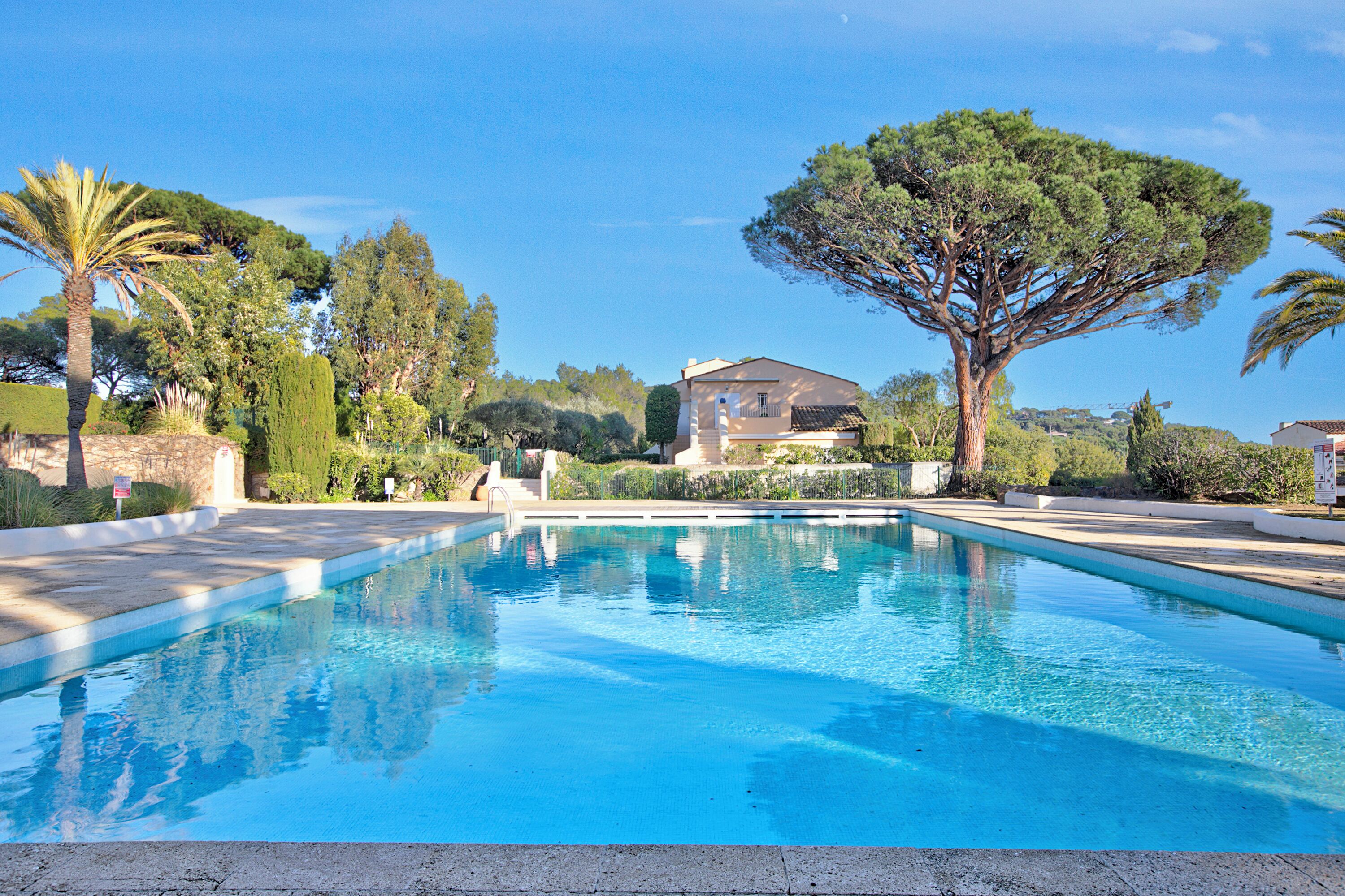 A swimming pool with a house in the background.