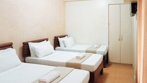 A hotel room with three single beds, each with white linens and pillows, and a wardrobe with two doors. - Reddoorz @ Casa Marabella Villamonte Bacolod City (Bacolod)
