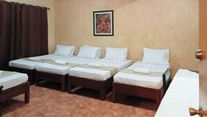 A hotel room with four single beds, a brown curtain, a framed picture on the wall, and a door with a brass handle. - Reddoorz @ Casa Marabella Villamonte Bacolod City (Bacolod)