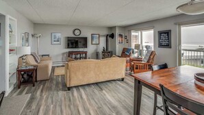 Una sala de estar con sofá, mesa de comedor, televisor y chimenea.