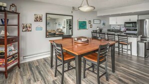 Una cocina moderna con comedor, piso de madera y un espejo grande.
