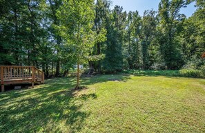 A grassy outdoor area with a wooden deck and a small tree. - Close to Fort Gregg-Adams, VSU & Southside Medical – Comfort & Convenience (Petersburg)