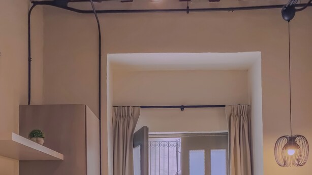 A room with a TV, a desk, a chair, a patterned rug, and a door leading outside. - Cozy 1-bedroom suite in amazing Puebla with King size bed, WiFi and bathtub (Heroica Puebla de Zaragoza)