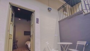A room with a bed, a small table, and two chairs. - Enchanting suite with WiFi, King size-bed in Puebla. excellent location. (Heroica Puebla de Zaragoza)