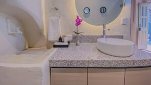 A modern bathroom with a round mirror, a bathtub, a sink, and a vanity with cabinets. - Enchanting suite with WiFi, King size-bed in Puebla. excellent location. (Heroica Puebla de Zaragoza)