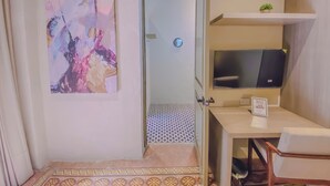 A modern room with a desk, chair, TV, and abstract art. - Enchanting suite with WiFi, King size-bed in Puebla. excellent location. (Heroica Puebla de Zaragoza)