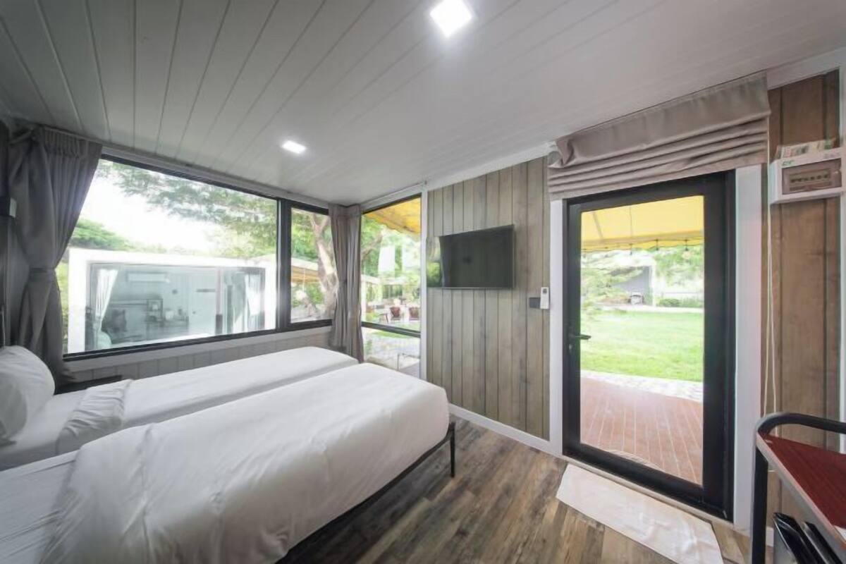 A bedroom with a bed, a TV, and a sliding glass door to an outdoor area.