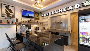A modern bar area with a large TV screen, a bar counter, and a refrigerator stocked with beverages. - Talay Pool Villa (Pattaya)
