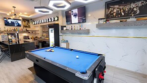 A pool table with a blue felt surface, a billiards cue, and a white cue ball. - Talay Pool Villa (Pattaya)