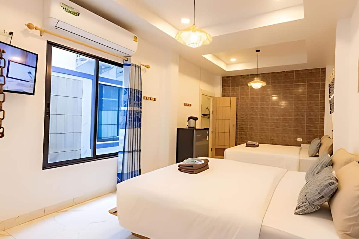 A modern hotel room with a large bed, a small desk, a wardrobe, and a view of the outside.