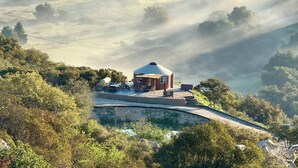 A circular building with a dome roof, surrounded by a stone wall and a small pool. - Fallbrook Airplane Home w/ Fire Pit & Mtn Views! (Fallbrook)