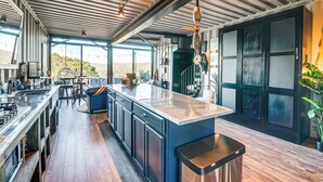 A modern kitchen with a large island, stainless steel appliances, and a view of the outdoors. - Fallbrook Airplane Home w/ Fire Pit & Mtn Views! (Fallbrook)