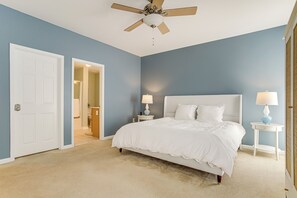 A bedroom with a single bed, two bedside tables with lamps, a ceiling fan, and a door leading to another room. - Deck, Hot Tub & Resort Amenities: Ocean View Gem (Ocean View)