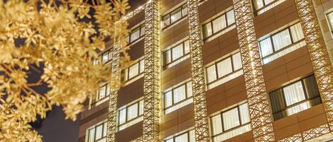 Un edificio de varios pisos con un diseño arquitectónico moderno, que destaca por una serie de ventanas y un frente con motivos decorativos.