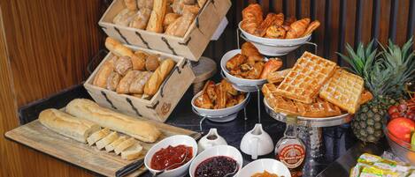 Ein Buffet mit verschiedenen Brotsorten, Gebäck, Waffeln und Beilagen.