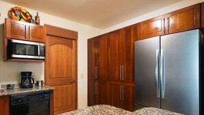 A kitchen with wooden cabinets, a stainless steel refrigerator, a microwave, and a coffee maker. - Best Views of Zihua 3Bed 3 Bath luxury (Zihuatanejo)