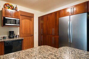 A kitchen with wooden cabinets, a stainless steel refrigerator, a microwave, and a coffee maker. - Best Views of Zihua 3Bed 3 Bath luxury (Zihuatanejo)