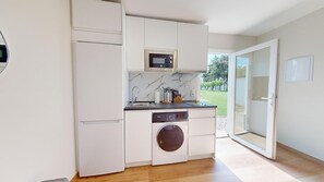 Una cocina compacta equipada con lavadora, microondas y lavavajillas.