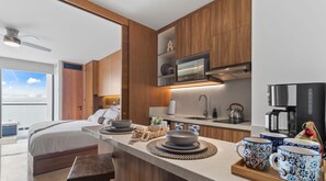 A modern kitchen with wooden cabinets, a built-in microwave, and a coffee maker.