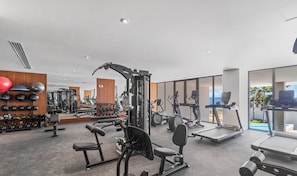 A modern gym with various exercise equipment, including treadmills and weight machines.