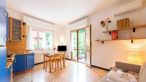 A compact hotel room with a kitchenette, dining area, and a sofa with towels. - Beautiful Flat in Rapallo (Rapallo)