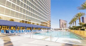 A hotel pool area with lounge chairs and a large building in the background. - Executive-style stay at Trump International in Las Vegas (Las Vegas)
