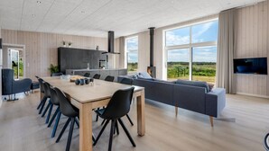 Una cucina moderna con zona pranzo, ampie finestre e una televisione a schermo piatto.