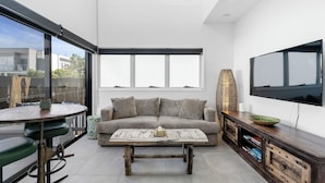 A modern living room with a sofa, coffee table, and TV.