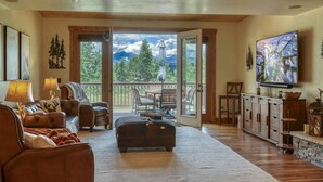 A spacious living room with a large window, a fireplace, and a television.