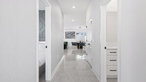 A modern hallway with a dining area in the background, featuring a table and chairs. - Vor4784hw: 5 Bed, Candy Land, Pool (Orlando)