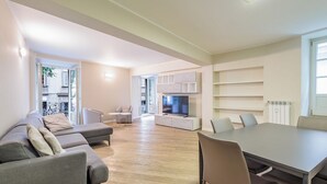 Una sala de estar moderna con un sofá, una mesa de comedor y un televisor.