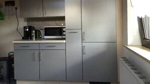 A compact kitchen with a microwave, coffee maker, and cabinets.
