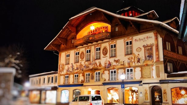 A building with a balcony, a sign with the year 1775, and a van parked in front.