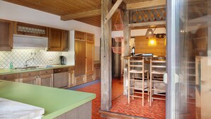 A kitchen with wooden cabinets, a green countertop, and a hanging basket.