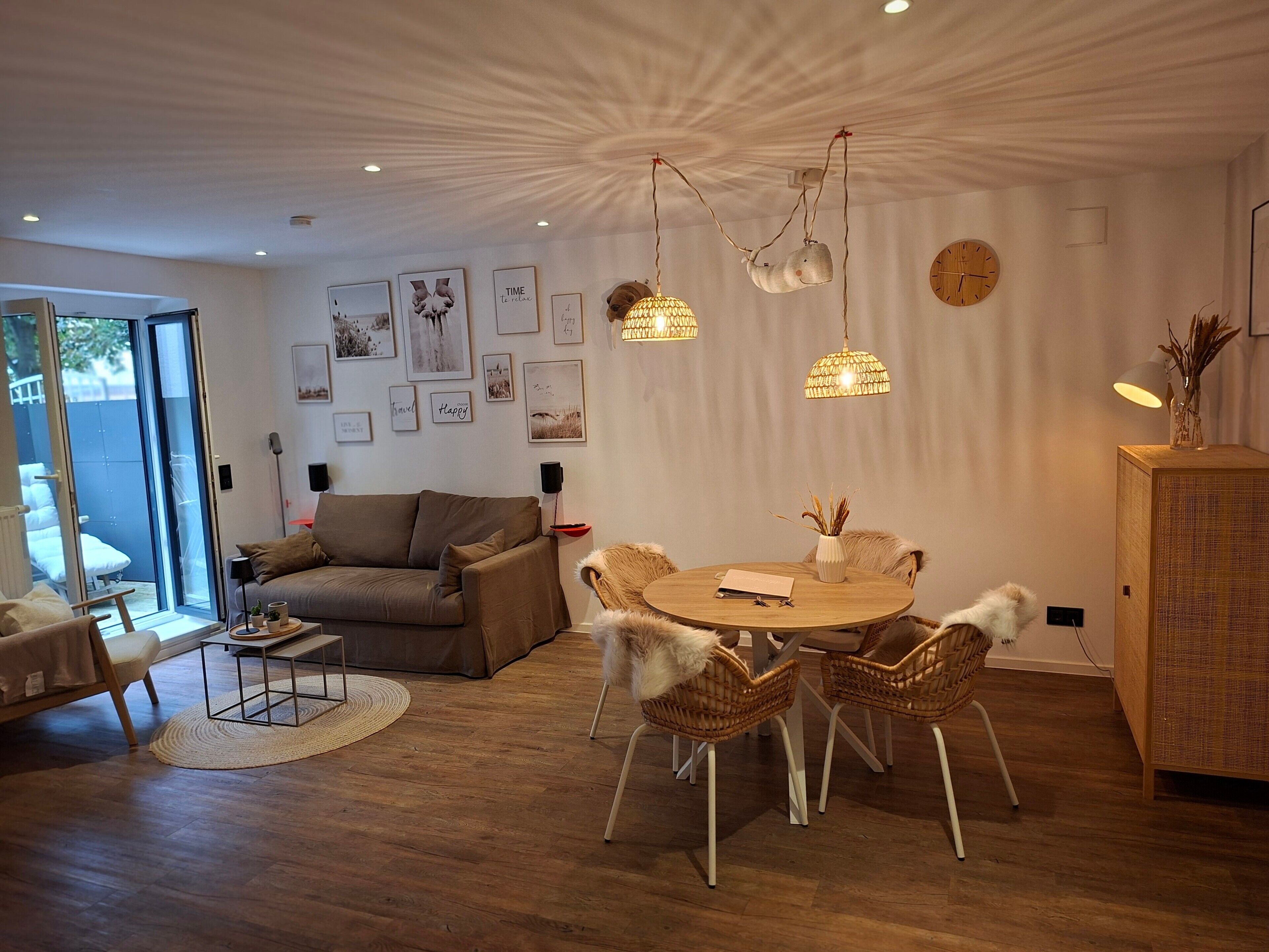 Ein modernes Wohnzimmer mit einem runden Esstisch, Korbstühlen, einer Couch und einer einzigartigen Deckenkonstruktion.