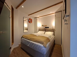 Ein Schlafzimmer mit einem Bett, Nachttischen, einem Spiegel und einem Wandregal.