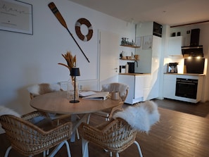 A modern kitchen with white cabinetry, a built-in oven, and a coffee machine. - 4**** DTV Apartment Lachmöwe von DeJu (Norderney)