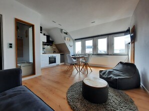 A modern apartment with a kitchen, dining area, and living space.