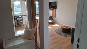 Ein modernes Wohnzimmer mit einer Couch, einem Fernseher und einem Holzboden.