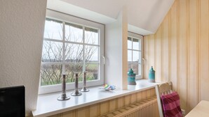Une pièce avec une fenêtre, un radiateur, une chaise et une table.