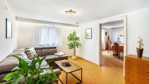 A living room with a sofa, coffee table, potted plants, and a dining area with a table and chairs. - Apartment 'Ferienhaus Albert' with Private Terrace and Wi-Fi (Bühl)