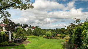 A well-maintained garden with a lawn, a patio area with seating, and a variety of plants and trees. - Apartment 'Ferienhaus Albert' with Private Terrace and Wi-Fi (Bühl)