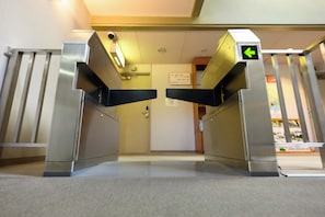 A turnstile entrance with a green directional arrow, a security camera, and a sign indicating room numbers 3301-3306 and 3307-3310. - Sansuikan Kawayu Matsuya (Tanabe)